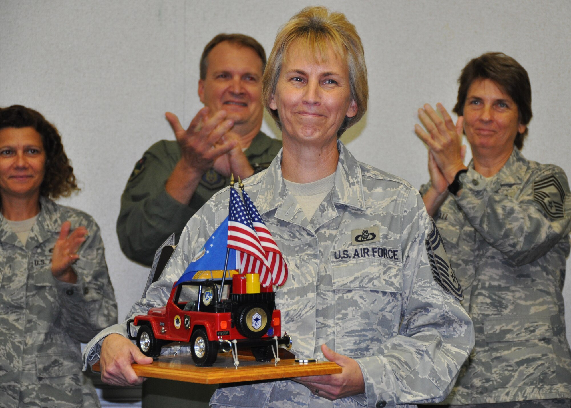 Newly promoted Chief Master Sgt. Darlene Peterson of the 711th Special Operations Squadron receives applause from her fellow chiefs during a ceremony officially inducting her into the Air Force’s highest enlisted rank Nov. 3 at Duke Field, Fla.   Following Air Force tradition, Peterson must not relinquish control of the toy Jeep memento she holds until the next new chief is likewise inducted.   (U.S. Air Force photo/Dan Neely)