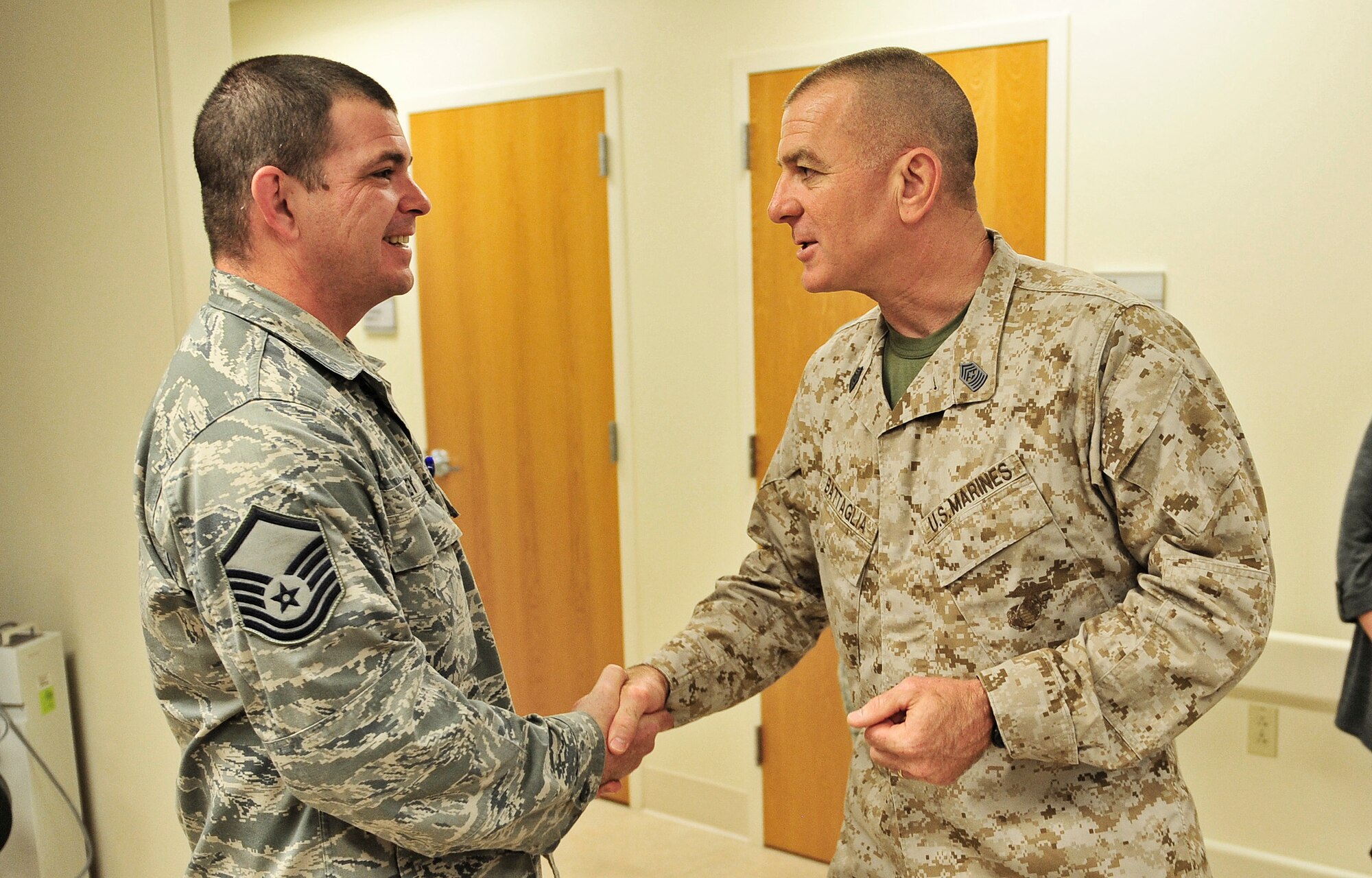 Sgt. Maj. Bryan Battaglia, Senior Enlisted Advisor to the Chairman Joint Chiefs of Staff, presents a coin to Master Sgt. Dennis Livezey, 375th Medical Operations Squadron physical therapy specialist, during a tour of Scott Air Force Base Oct. 30, 2012. Battaglia serves as the principal advisor to the Chairman and Secretary of Defense on all matters involving joint and combined total force integration, utilization, health of the force and joint development for enlisted personnel. (U.S. Air Force photo/ Staff Sgt. Ryan Crane)