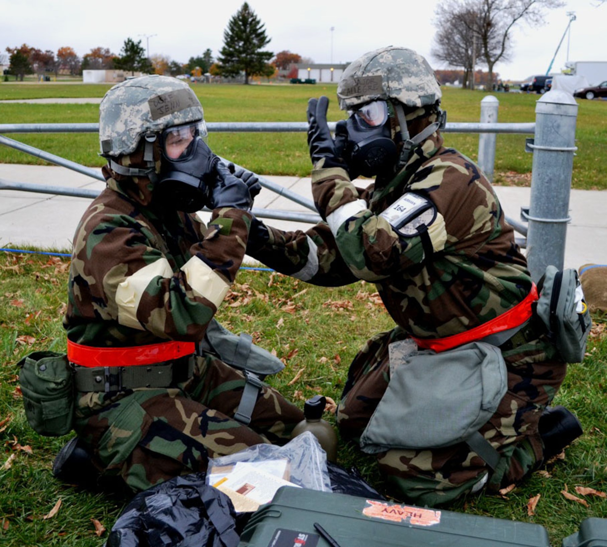 Chaplain (Maj.) Pierre Allegre (right) assists Tech. Sgt. Jennifer DeLucia , 446th Airlift Wing historian in getting her M-50 gas mask drinking tube ready for use during an Operational Readiness Inspection at Volk Field Combat Readiness Training Center, Wis. Oct. 13-20.  The 446th AW teamed up with its active-duty brothers and sisters from the 62nd Airlift Wing and 627th Air Base Group for the inspection. (Courtesy photo)