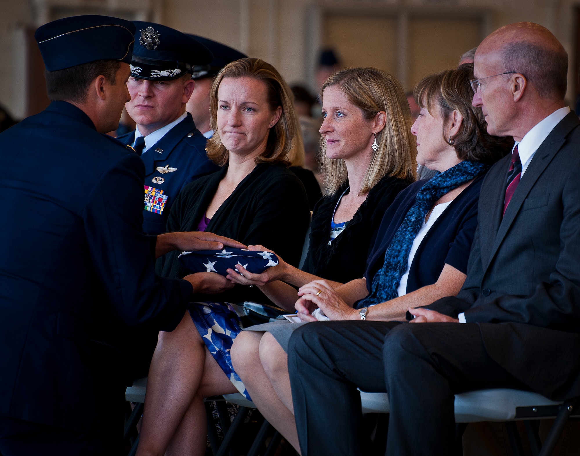 Maj. Garrett Knowlan’s widow, Megan, accepts the American flag flown over his burial at a memorial ceremony Nov. 5 at Eglin Air Force Base, Fla.  Knowlan died while participating in Air Force Survival, Evasion, Resistance and Escape training at the Naval Air Station in Pensacola.  The memorial service brought family, friends and co-workers together to say their final goodbyes.  (U.S. Air Force photo/Samuel King Jr.)