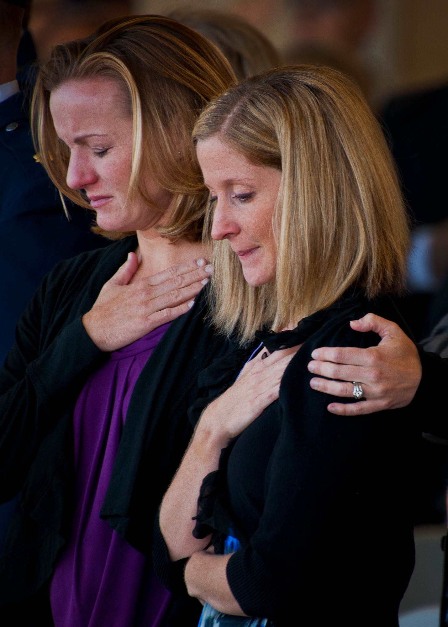 Maj. Garrett Knowlan’s widow, Megan, and his sister, Ericka Russell, listen to Taps during a memorial ceremony Nov. 5 at Eglin Air Force Base, Fla.  Knowlan died while participating in Air Force Survival, Evasion, Resistance and Escape training at the Naval Air Station in Pensacola.  The memorial service brought family, friends and co-workers together to say their final goodbyes.  (U.S. Air Force photo/Samuel King Jr.)