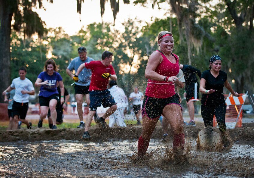 Runners jump in and run through a giant mud pit to escape the undead at the first-ever Zombie Stomp run at Eglin Air Force Base, Fla., Nov. 3.  More than 425 fearless runners braved zombie-infested woods, water and mud hazards and other obstacles over a 4.5 mile course.  (U.S. Air Force photo/Samuel King Jr.)