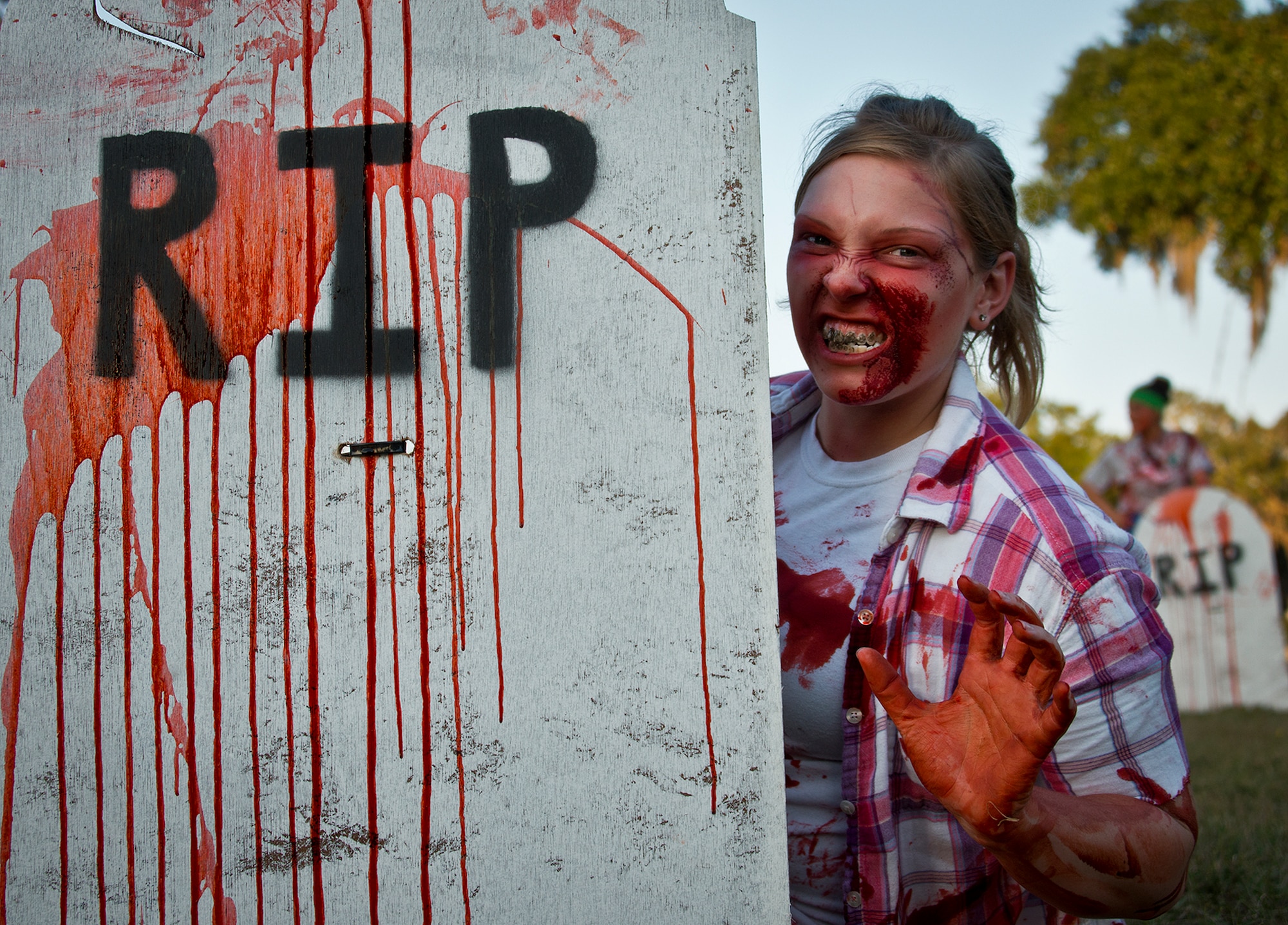 A zombie peeks around a tombstone waiting for a runner during the first-ever Zombie Stomp run at Eglin Air Force Base, Fla., Nov. 3.  More than 425 fearless runners braved zombie-infested woods, water and mud hazards and other obstacles over a 4.5 mile course.  (U.S. Air Force photo/Samuel King Jr.)