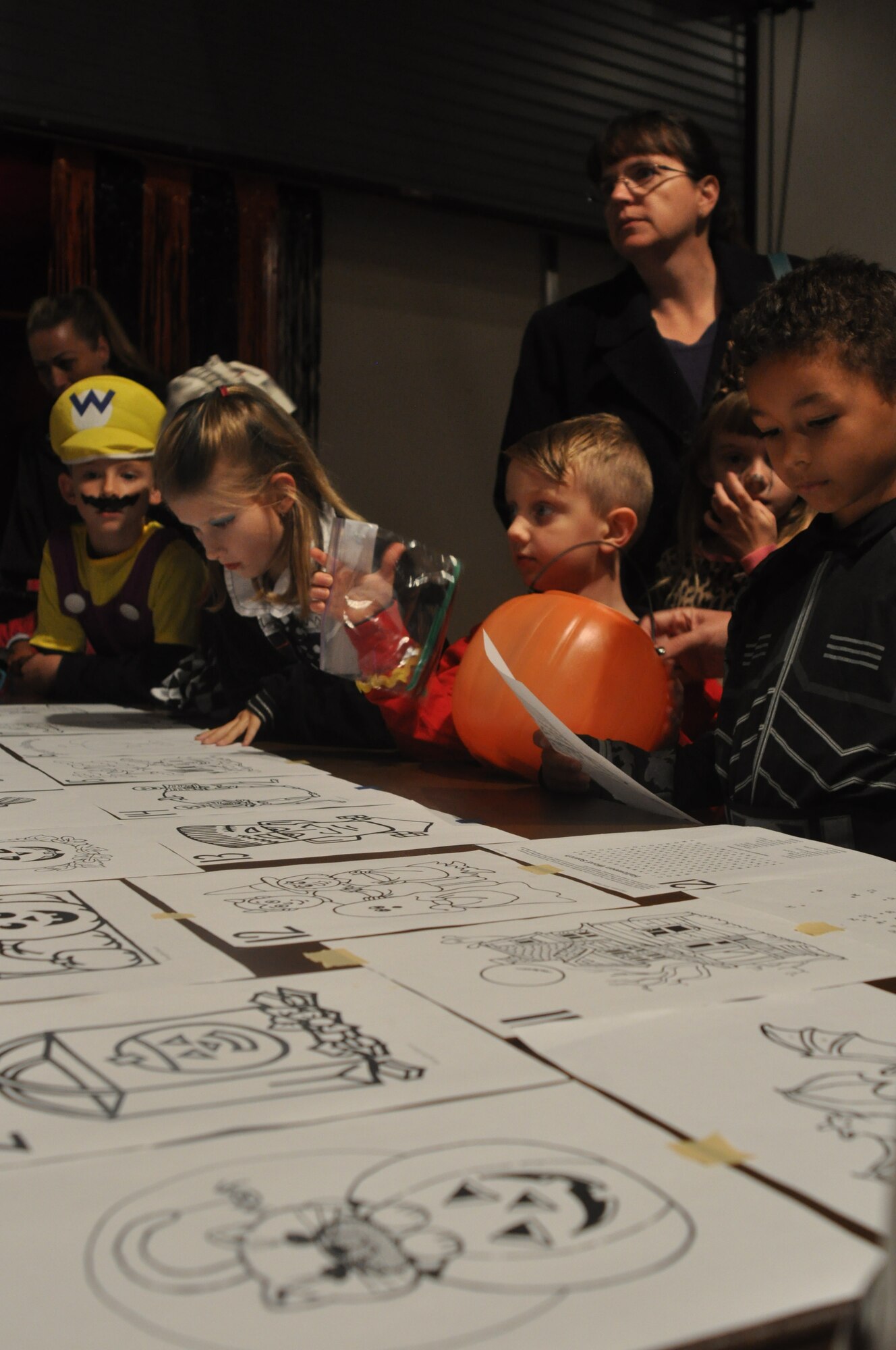 Children wait eagerly to pick their favorite coloring book sheet at the U.S. Army Transportation Museum's "Night at the Transportation Museum" event at Fort Eustis, Va., Oct. 31, 2012. More than 500 children attended the Halloween event at the museum, collecting candy, crafts, and a few scares from the museum's staff and volunteers hiding out in the darkness of the museum'x exhibits. (U.S. Air Force photo by Senior Airman Jason J. Brown/Released)