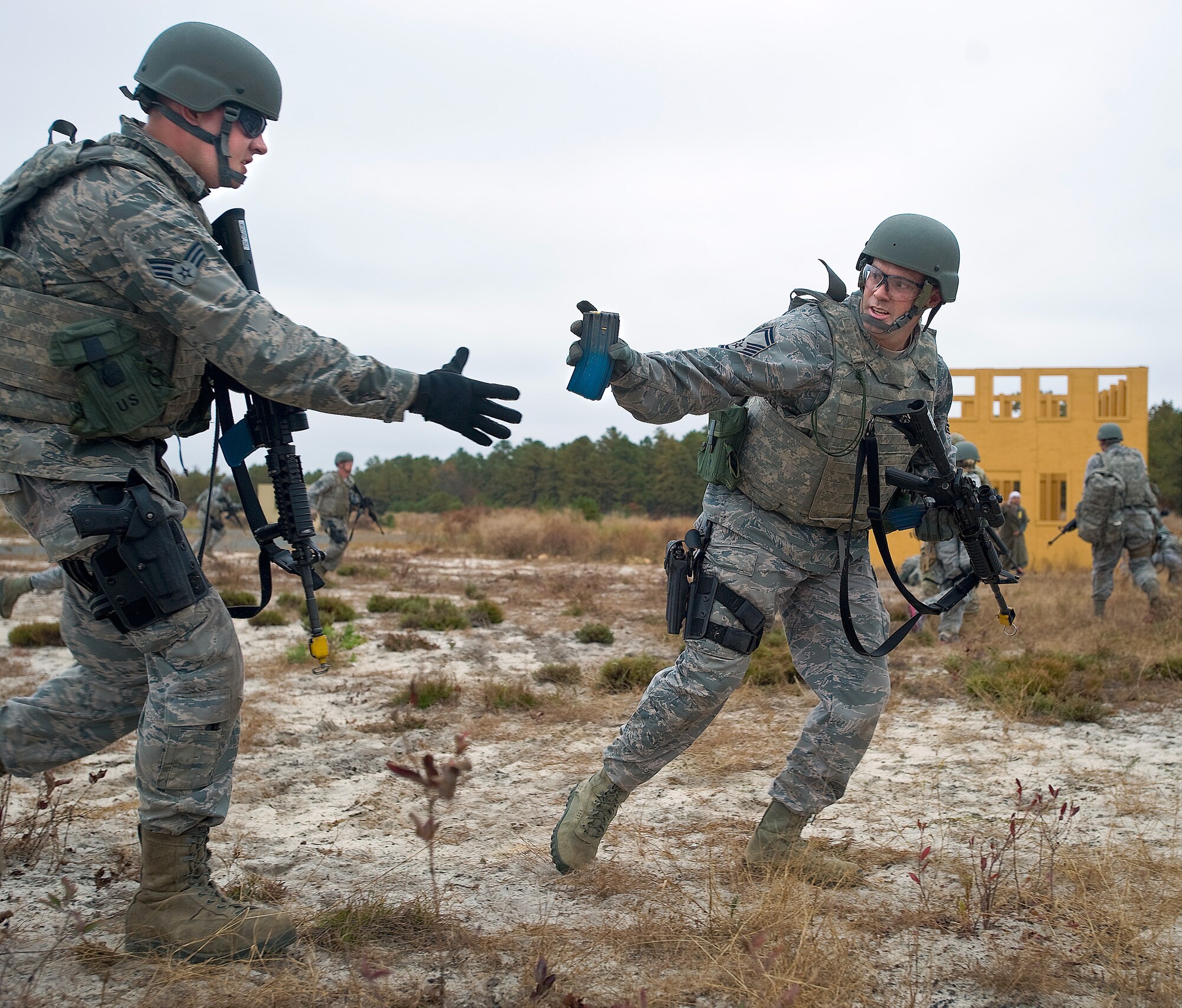 Senior Master Sgt. Daniel Spain, center, air freight superintendant with the 436th Aerial Port Squadron, hands a simulated magazine to Senior Airman Jonathon Martin, cargo processing specialist with the 436th Aerial Port Squadron, during the Combat Airman Skills Training field training exercise Oct. 25, 2012, at Joint Base McGuire-Dix-Lakehurst, N.J. Twenty aerial porters from the 436th APS completed CAST in preparation for a deployment. (U.S. Air Force photo by Airman 1st Class Sam Taylor)