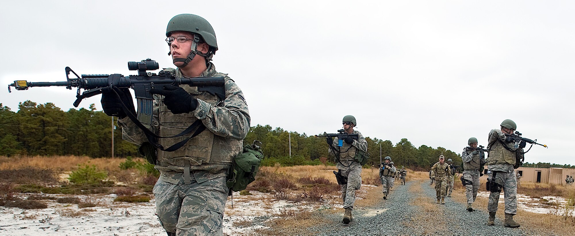 Airman 1st Class Jack Sand, a cargo processing specialist with the 436th Aerial Port Squadron, examines the simulated battlefield as squad mates search for simulated combatants during the Combat Airman Skills Training field training exercise Oct. 25, 2012, at Joint Base McGuire-Dix-Lakehurst, N.J. The FTX tested the skills Airmen learned during the 10-day CAST course. (U.S. Air Force photo by Airman 1st Class Sam Taylor)