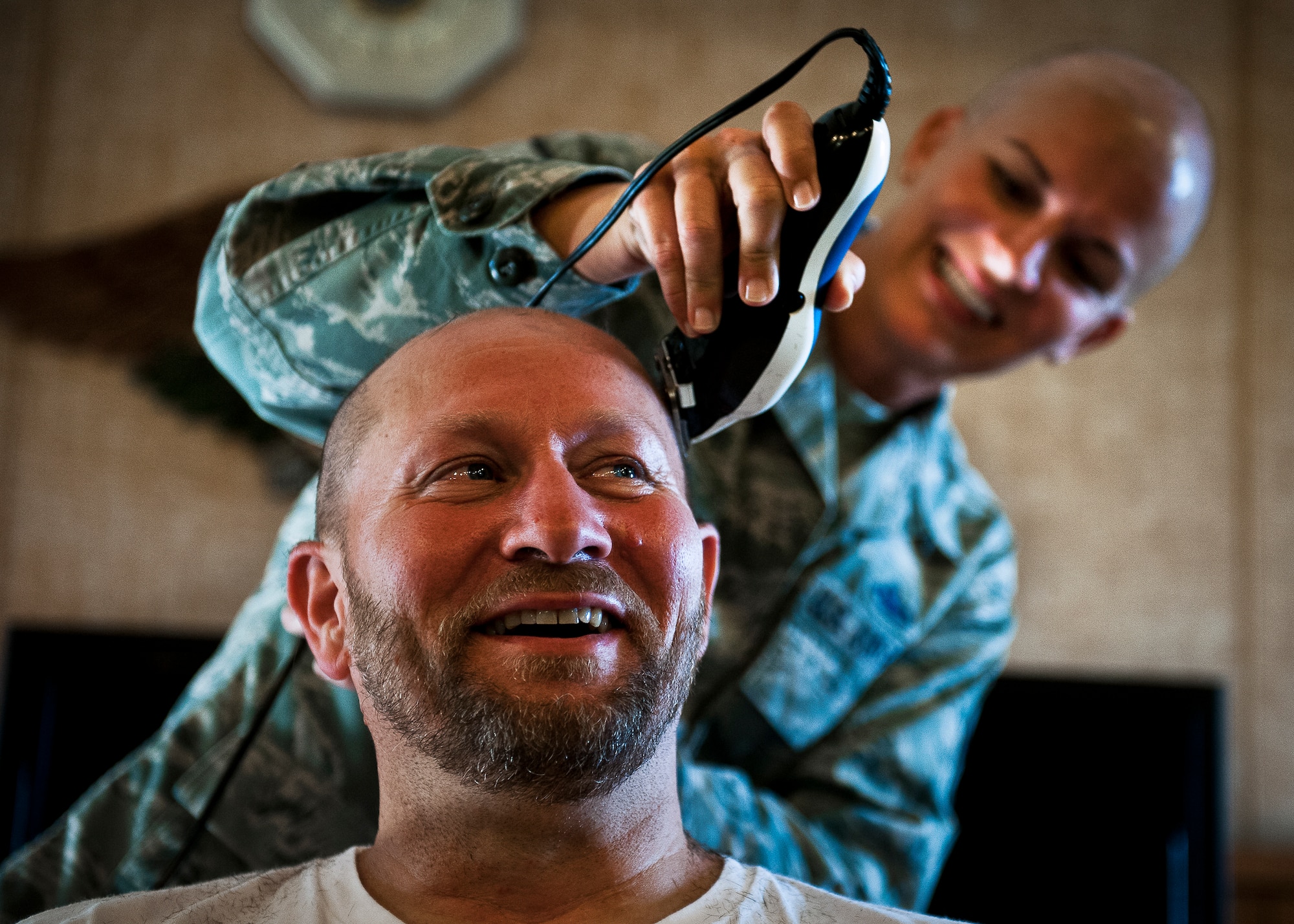 Dr. Kevin Partlow, of the 96th Logistics Readiness Squadron, reacts to having his head shaved by Master Sgt. Catherine Holland, of the 96th Fuels Management Flight, during a Combined Federal Campaign fundraising event Nov. 2 at Eglin Air Force Base, Fla.  The event was in support of Holland, who had a double mastectomy in August and is currently undergoing chemotherapy treatment.  The fundraiser to see who would get their head shaved by Holland raised $722 dollars for the Susan G. Komen Foundation. Partlow and three others received the most donations/votes to see them get their head shaved.  (U.S. Air Force photo/Samuel King Jr.)