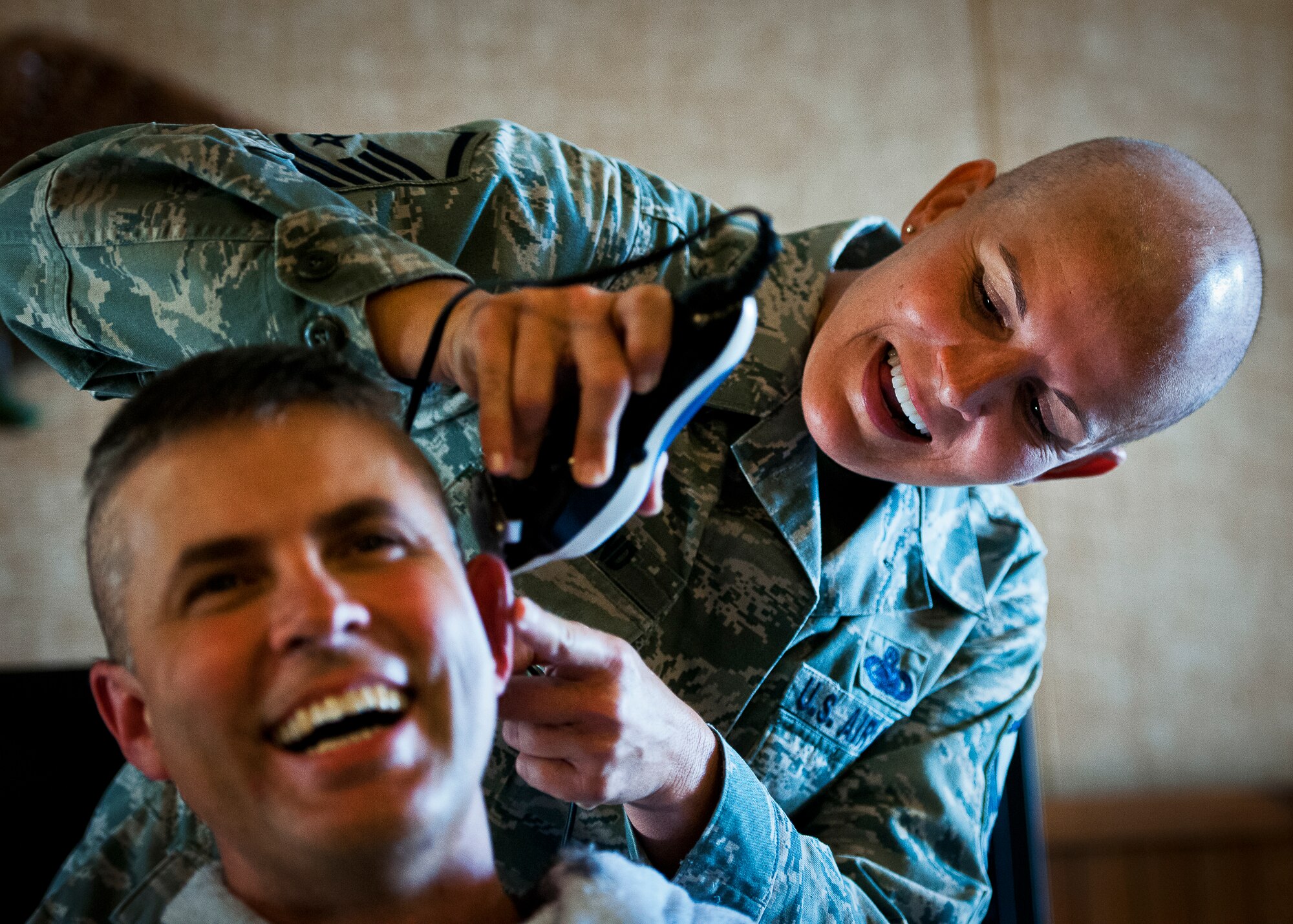 Master Sgt. Catherine Holland shaves behind the ear of Lt. Col. Rick Hughes, the 96th Logistics Readiness Squadron commander, during a Combined Federal Campaign fundraising event Nov. 2 at Eglin Air Force Base, Fla.  The event was in support of Holland, who had a double mastectomy in August and is currently undergoing chemotherapy treatment.  The fundraiser to see who would get their head shaved by Holland raised $722 dollars for the Susan G. Komen Foundation. Hughes and three others received the most donations/votes to see them get their head shaved.  (U.S. Air Force photo/Samuel King Jr.)