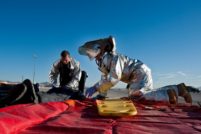 Airman 1st Class James Klaszky and Kevin Smith, 99th Civil Engineer Squadron firefighters, treat a simulated burn victim during a Major Accident Response Exercise, Nov. 2, 2012, at Nellis Air Force Base, Nev. The exercise was conducted in preparation for the upcoming 2012 Aviation Nation open house. (U.S. Air Force photo by Airman 1st Class Jason Couillard)
