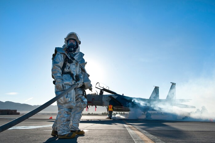 Staff Sgt. Timothy Cruz and Staff Sgt. Michael Gongora, 99th Civil Engineer Squadron firefighters, participate in a Major Accident Response Exercise that involved a simulated mid-air collision, Nov. 2, 2012, at Nellis Air Force Base, Nev. The objective of the exercise was to assess the installation’s response to a major aircraft accident. (U.S. Air Force photo by Airman 1st Class Jason Couillard)