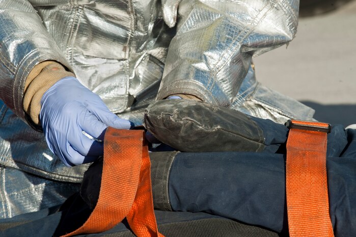 Airman 1st Class James Klaszky, 99th Civil Engineer Squadron firefighter, straps a simulated burn victim to a litter during a Major Accident Response Exercise, Nov. 2, 2012, at Nellis Air Force Base, Nev.  The scenario tested the base’s ability to respond to an emergency situation during an open house event. (U.S. Air Force photo by Airman 1st Class Jason Couillard)