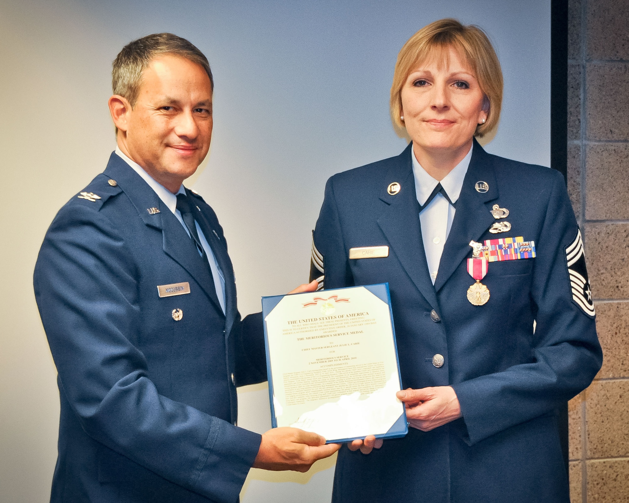 Chief Master Sgt. Julie L. Carie, 934th Airlift Wing financial management superintendent, receives the Meritorious Service Medal from Col. Todd J. McCubbin, 934th Airlift Wing vice commander, Nov. 3. (U.S. Air Force Photo/Staff Sgt. Kimberly Hickey)