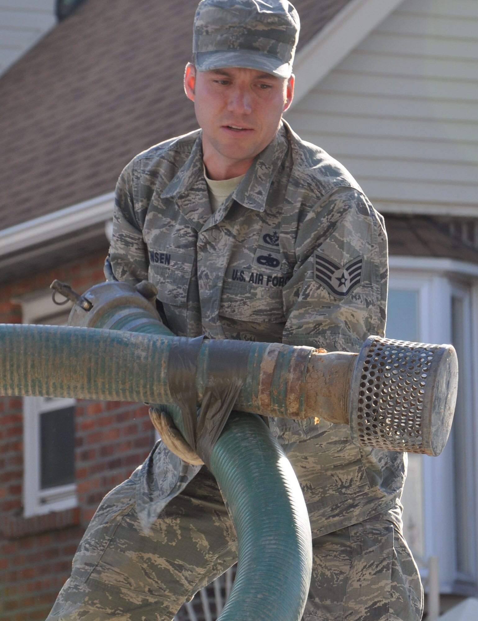 Staff Sgt. Erick Jensen, of the 28th Civil Engineer Squadron from Ellsworth Air Force Base, S.D., unloads are large hose used to pump water from homes devastated by flood water during the recent super storm, Nov. 5, 2012. Jensen is part of the 331st Air Expeditionary Group, made up of nearly 50 Air Force civil engineers from various duty locations across the country, who staged personnel and equipment at Joint Base McGuire-Dix-Lakehurst, N.J. during their support operations.  (U.S. Air Force photo by Capt. Sybil Taunton/Released)