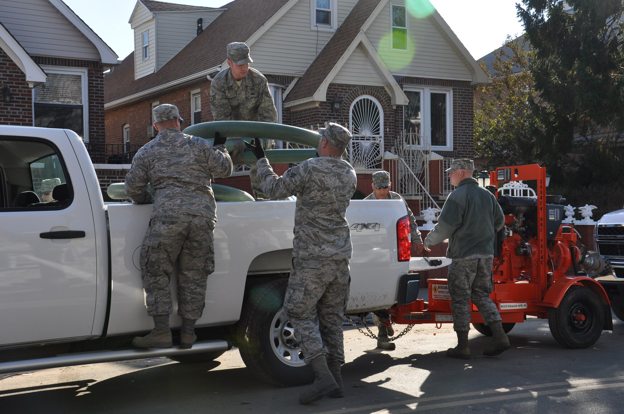 Members of the 331st Air Expeditionary Group, a unit comprised of civil engineers from 5 different duty locations across the U.S., unload large hoses used to pump water from homes devastated by flood water left behind by Hurricane Sandy, Nov. 5, 2012. The 331st AEG staged personnel and equipment at Joint Base McGuire-Dix-Lakehurst, N.J. during their support operations.  (U.S. Air Force photo by Capt. Sybil Taunton/Released)