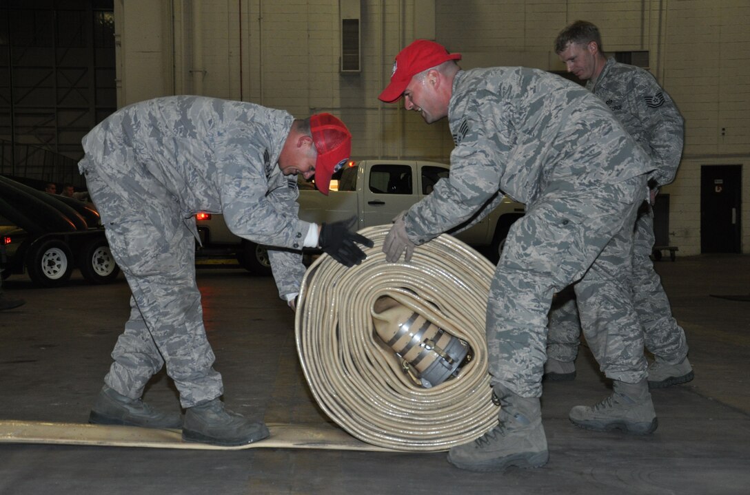 Staff Sgt. John Johnson and Senior Airman Jerl Dunn, of the 823rd Red Horse Squadron, from Hurlburt Field, Fla., role a low-pressure hose and before loading it onto a trailer while staged at Joint Base McGuire-Dix-Lakehurst, N.J., Nov. 4, 2012, to prepare for hurricane relief operations. Approximately 50 Air Force civil engineers and 12 industrial pumps were sent from different locations around the country to form the 331st Air Expeditionary Group, whose mission is to help clear flood water from critical areas damaged by Hurricane Sandy.  (U.S. Air Force photo by Capt. Sybil Taunton/Released)