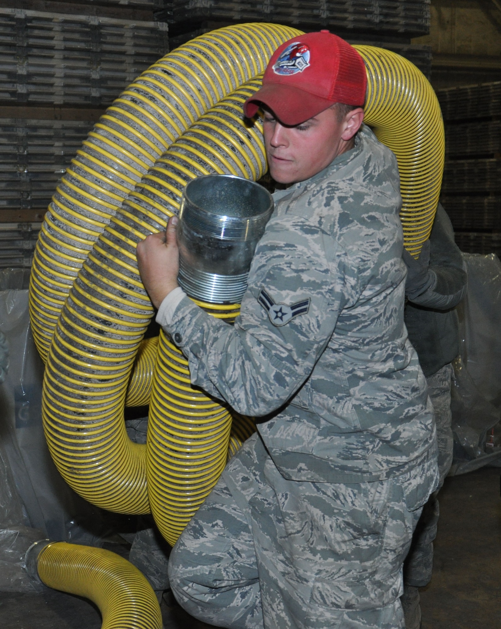 Airman 1st Class Brandon McConnell, of the 823rd Red Horse Squadron from Hurlburt Field, Fla., lifts a large hose onto a trailer at Joint Base McGuire-Dix-Lakehurst, N.J., Nov. 4, 2012, in preparation for hurricane relief operations. Approximately 50 Air Force civil engineers were activated as part of the 331st Air Expeditionary Group, sent to pump flood water from critical areas effecting New York communities. (U.S. Air Force photo by Capt. Sybil Taunton/ Released)