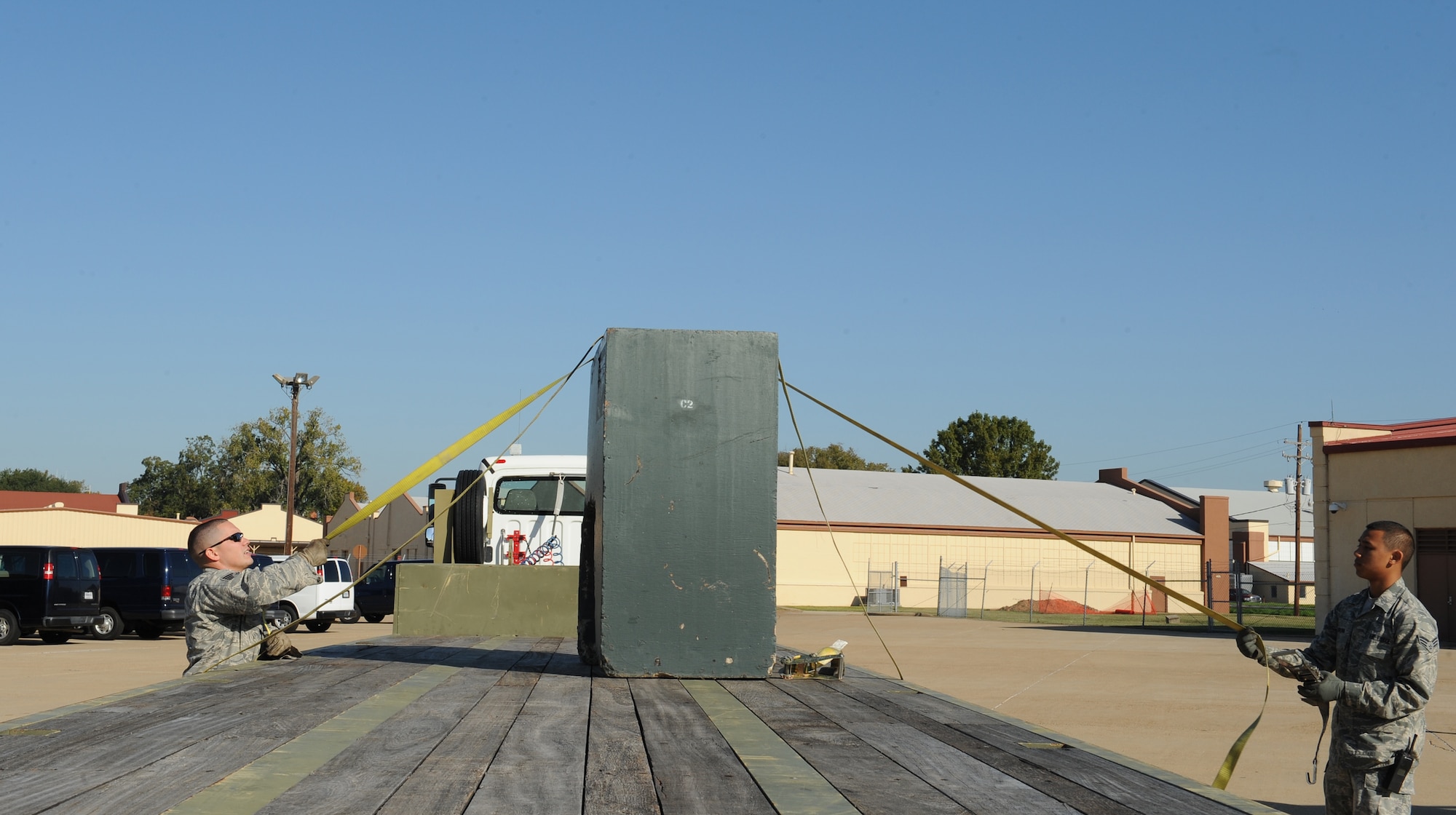 Staff Sgt. Randy Moorhouse, 2nd Logistics Readiness Squadron Vehicle Operations craftsman, and Senior Airman Pierre Brown, 2 LRS VO journeyman, tie a training block onto a 45 foot trailer during a training scenario on Barksdale Air Force Base, La., Oct. 31. Vehicle operators drive high ranking individuals from the Air Force and its sister services, as well as foreign dignitaries and groups touring the base. (U.S. Air Force photo/Airman 1st Class Benjamin Gonsier)(RELEASED)
