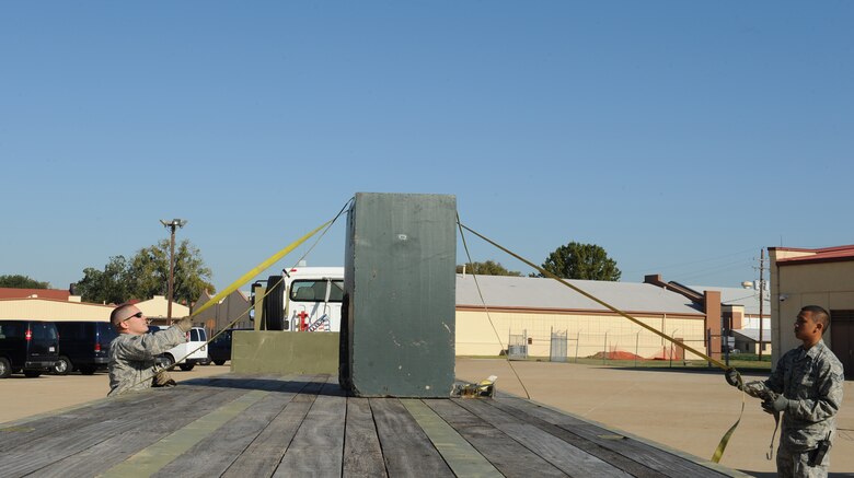 Staff Sgt. Randy Moorhouse, 2nd Logistics Readiness Squadron Vehicle Operations craftsman, and Senior Airman Pierre Brown, 2 LRS VO journeyman, tie a training block onto a 45 foot trailer during a training scenario on Barksdale Air Force Base, La., Oct. 31. Vehicle operators drive high ranking individuals from the Air Force and its sister services, as well as foreign dignitaries and groups touring the base. (U.S. Air Force photo/Airman 1st Class Benjamin Gonsier)(RELEASED)