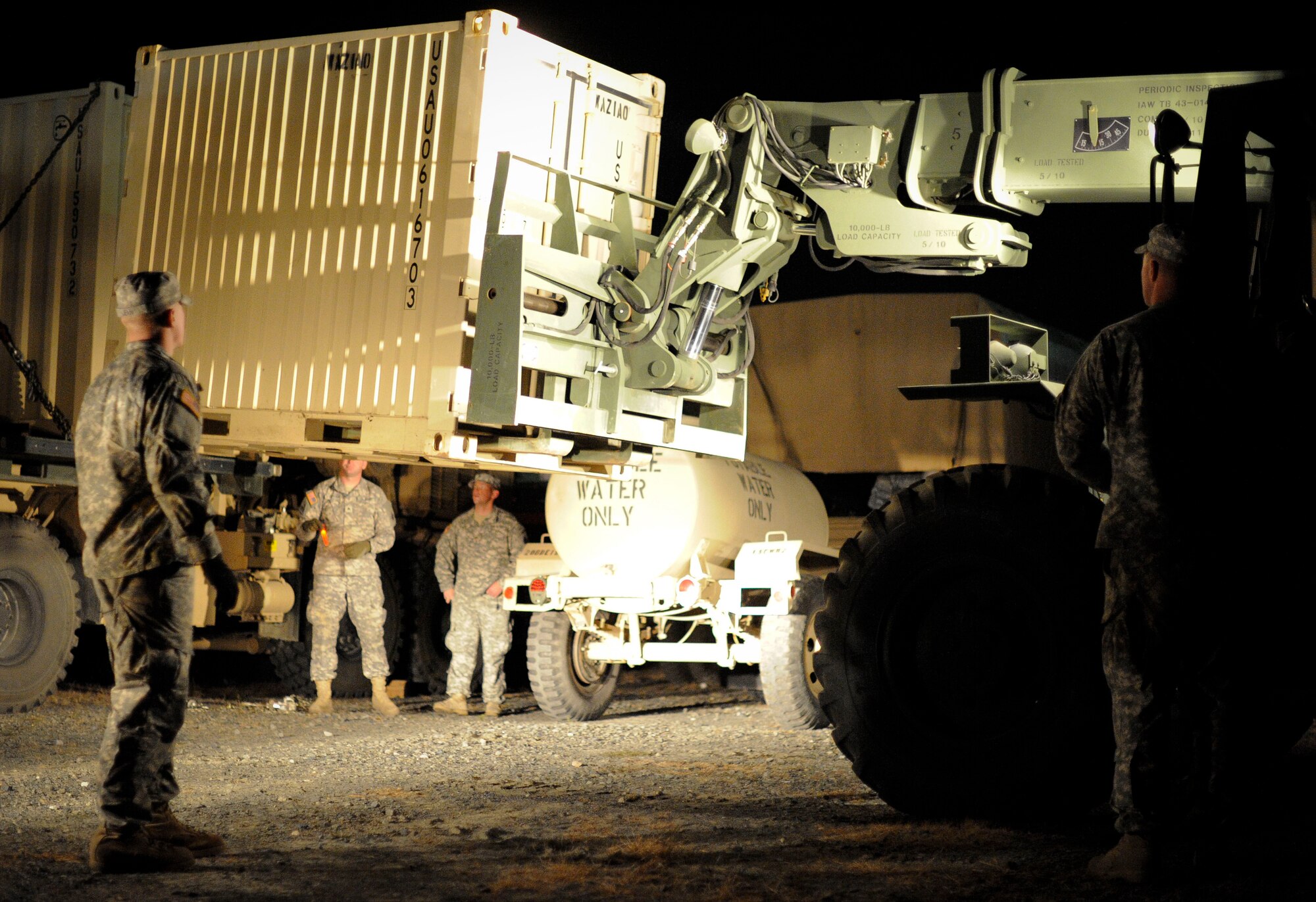 Crew members with the 19th Engineer Battalion, deployed from Ft. Knox, Ky., remove shipping crates from a truck Nov. 6, 2012, at the Contingency Operating Location on the Dix ranges here. The COL is being used as a staging area for Department of Defense and Federal Emergency Management Agency assets. The shipping containers hold water pumps which will be used throughout New Jersey and New York as part of the Hurricane Sandy relief effort. (U.S. Air Force photo by Airman 1st Class Ryan Throneberry/Released)