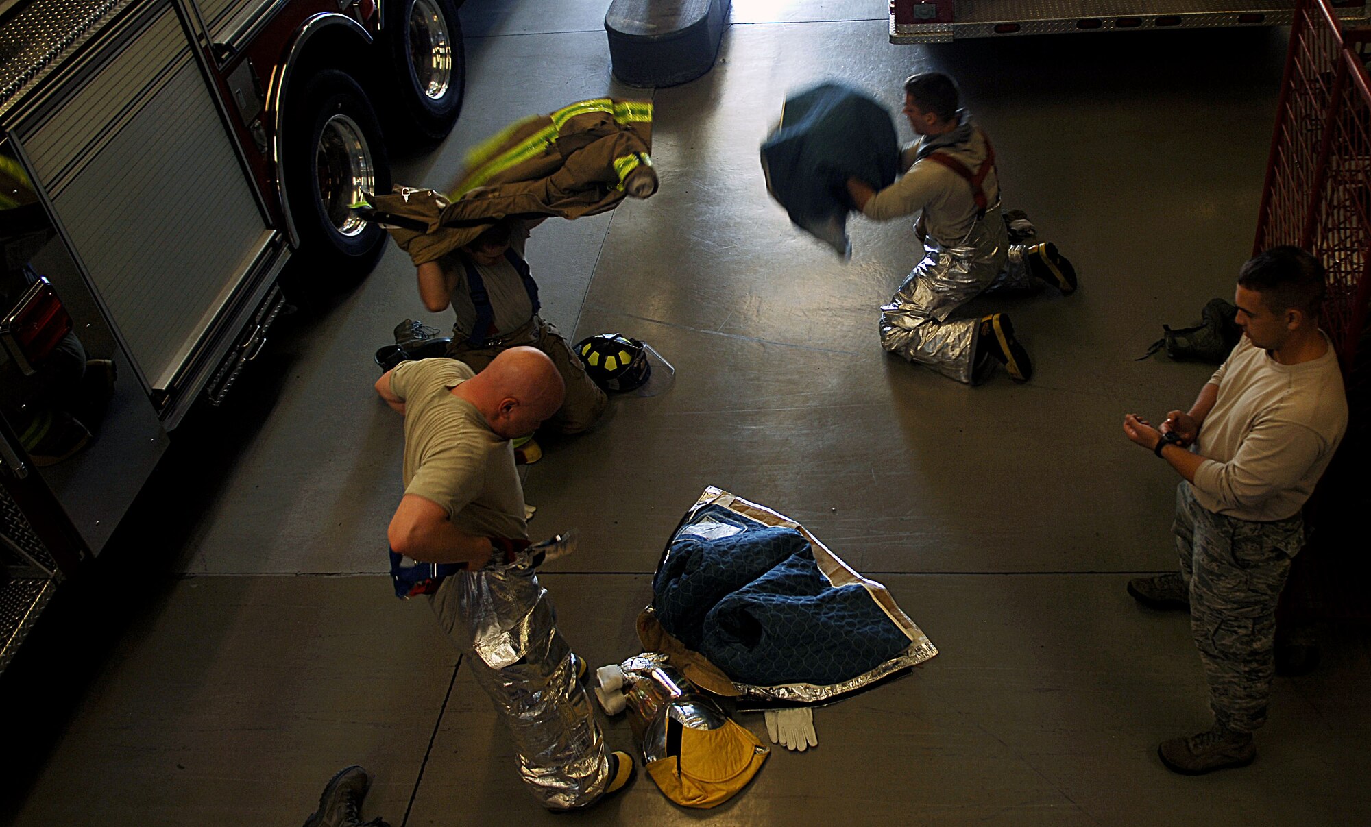 Chaplain Capt. Michael McDonald (bottom left), 633r Air Base Wing chaplain, practices donning protective gear with his team during the Chaplain’s Challenge at the Langley Air Force Base, Va., fire department, Nov. 1, 2012.  The team had 60 seconds to don all gear. (U.S. Air Force photo by Staff Sgt. Katie G. Ward / Released)