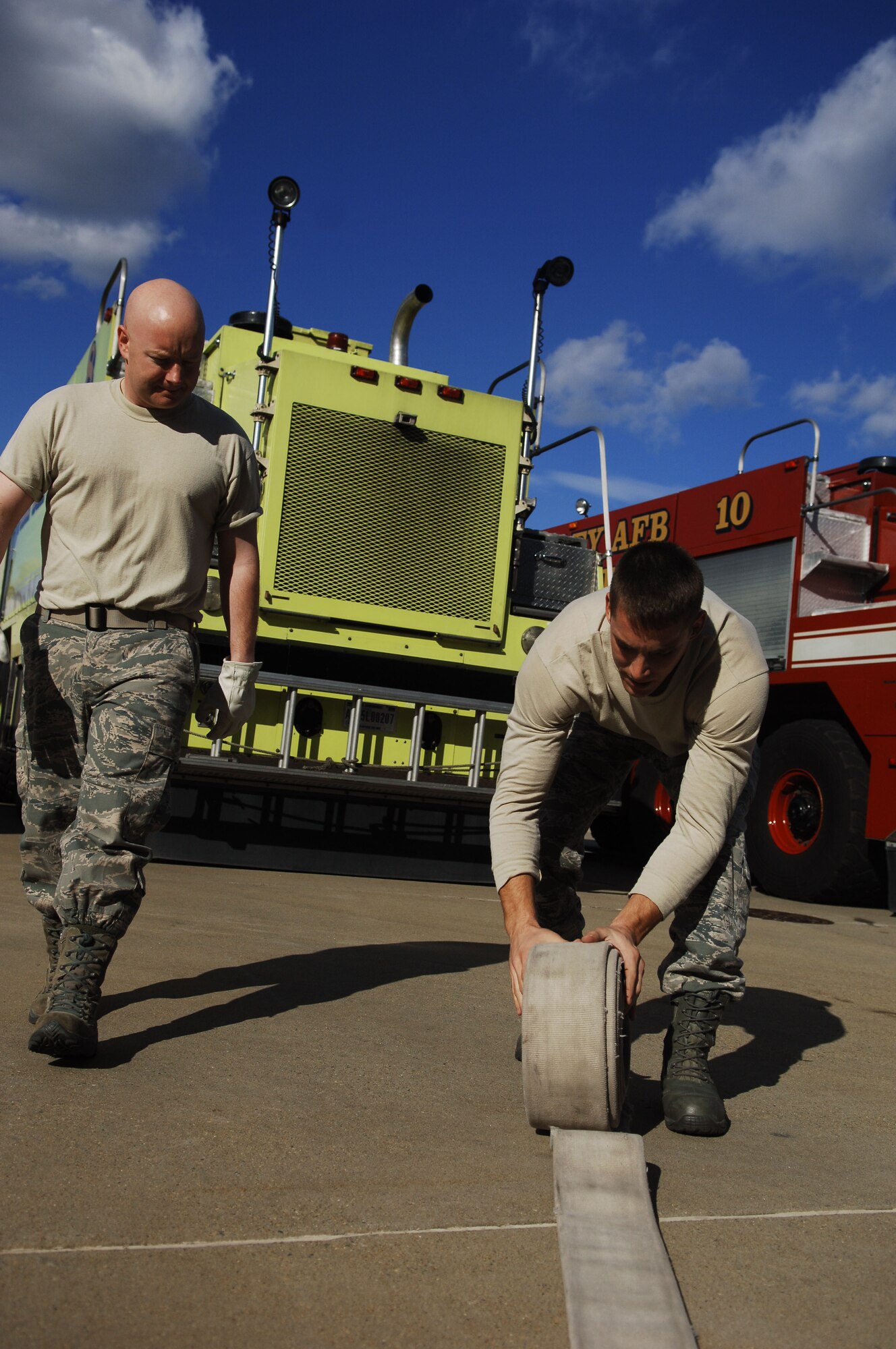 Chaplain Capt. Michael McDonald (left), 633rd Air Base Wing chaplain, is taught by a teammate how to reroll a fire house during the Chaplain’s Challenge with the Langley Air Force Base, Va., fire department, Nov. 1, 2012.  Throwing and rerolling a fire hose was one of the various time-sensitive events during the challenge. (U.S. Air Force photo by Staff Sgt. Katie G. Ward / Released)