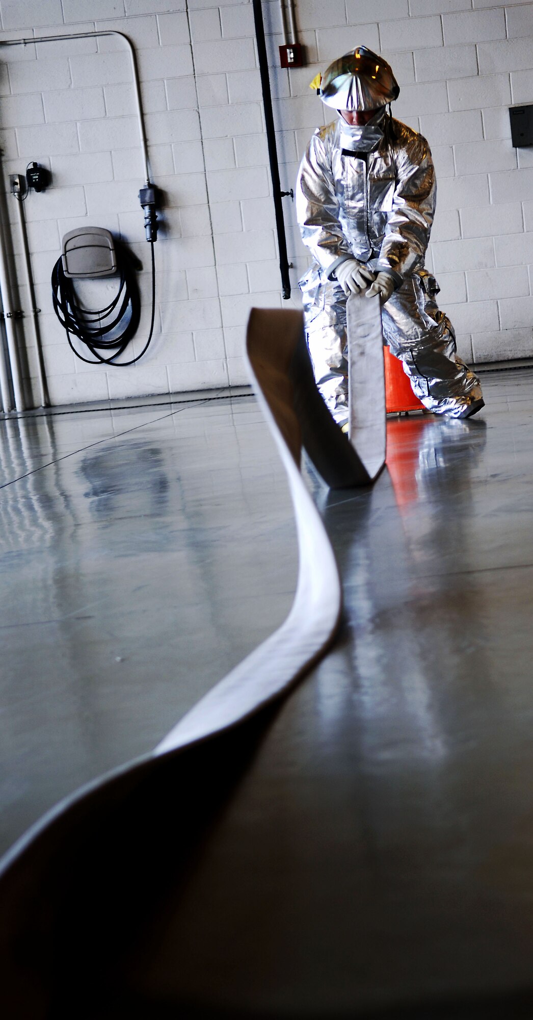 Chaplain Capt. Michael McDonald, 633rd Air Base Wing chaplain, rerolls a fire house during the Chaplain’s Challenge with the Langley Air Force Base, Va., fire department, Nov. 1, 2012.  McDonald said the challenge allows Airmen to feel more comfortable talking to chaplains. (U.S. Air Force photo by Staff Sgt. Katie G. Ward / Released)