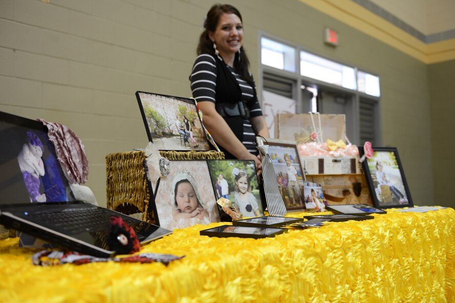Rebekah Lewing, Enlisted Spouses Club member stands behind her photography stand advertising her work from her business, Lewing Photography, at the “Give Thanks Bazaar”, Shaw Air Force Base, S.C., Nov. 3, 2012. (U.S. Air Force photo by Airman 1st Class Daniel Blackwell/Released)