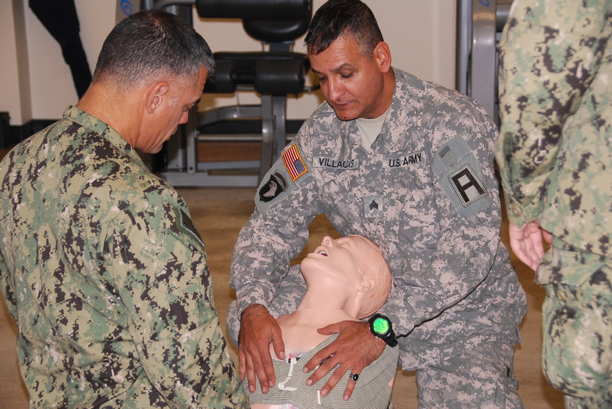 JOINT BASE MCGUIRE-DIX-LAKEHURST, N.J. -- Army Sgt. Juan Villacis, 174th Infantry Brigade Combat Lifesaver Trainer/Mentor demonstrates dressing a penetrating chest wound on a manikin during Combat Lifesaver training Nov. 1. The training was moved to the brigade headquarters gym due to the power outage at the CLS building from Hurricane Sandy. (U.S. Army photo by  Capt. Antonia T. Greene-Edwards/Released)