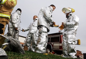Chaplain Capt. Michael McDonald (right), 633rd Air Base Wing chaplain, is fitted for protective gear in preparation for the Chaplain’s Challenge with the Langley Air Force Base, Va., fire department, Nov. 1, 2012.  This is the first time they have brought the challenge to the fire department. (U.S. Air Force photo by Staff Sgt. Katie G. Ward / Released)