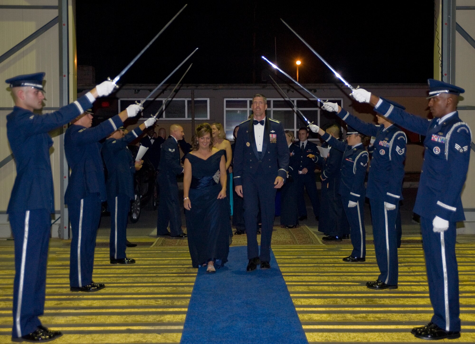Col. Chris Craige, 39th Air Base Wing commander, and his wife, Penny, walk through the saber line during the Formal Dining-Out ceremony Nov. 3, 2012, at Incirlik Air Base, Turkey. Formal military dinners are a tradition in all branches of the U.S. armed forces, and the dining-out represents one of the most formal aspects of Air Force social life. The ceremony enhances esprit de corps and lightens the load of demanding day-to-day work. (U.S. Air Force photo by Senior Airman Anthony Sanchelli/Released)
