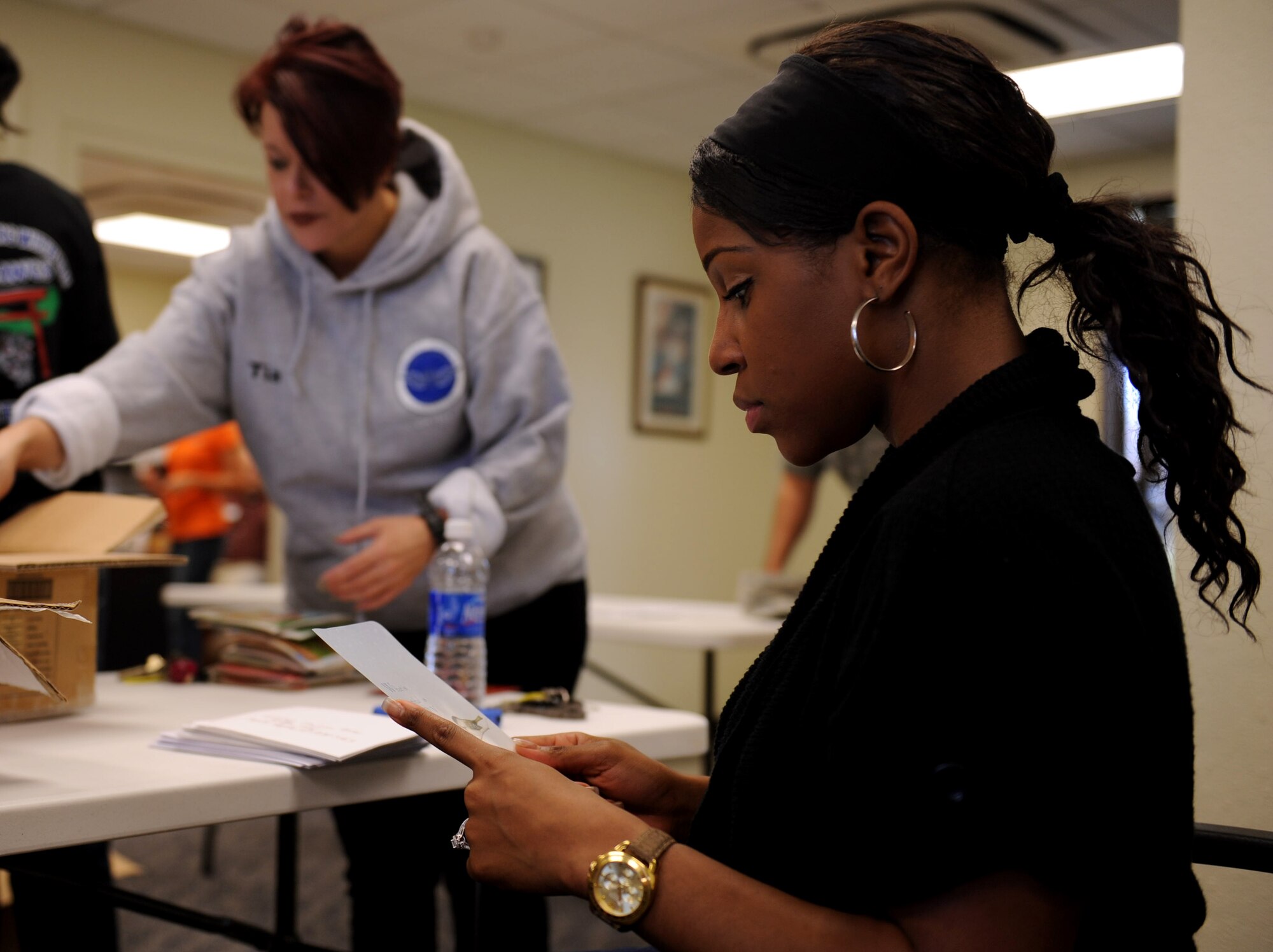 U.S. Air Force Staff Sgt. Janay Stokes, 18th Security Forces Squadron investigator, reads a Christmas card during the American Red Cross Cards for Airmen screening on Kadena Air Base, Japan, Nov. 1, 2012. Kadena Airmen volunteered for the card screening to aid the distribution of the cards for this upcoming holiday season.  The cards will be distributed to dining and lodging facilities, as well as the Cookie Caper event, where citizens can volunteer to bake cookies that will be taken to the dorms of single service members. (U.S. Air Force photo/Airman 1st Class Hailey R. Davis)
