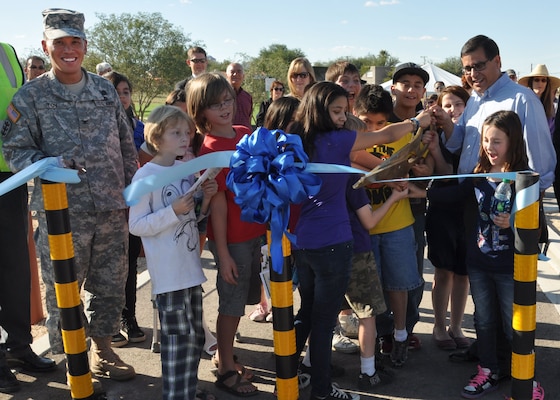 TUCSON, Ariz.- Col. Mark Toy, U.S. Army Corps of Engineers Los Angeles District commander, ceremonially completes the project at the Nov. 2 ribbon-cutting ceremony for the Tucson  Arroyo Project Phase II B Park Avenue Basins project while a group of students from the nearby Highland Free School cut the ribbon with Ramon Valadez, the Pima County Board of Supervisors chairman. The project, developed in partnership with the Pima County Regional Flood Control District; the City of Tucson; the Tucson Unified School District and the Corps of Engineers is designed to provide for flood risk management and ecosystem restoration along the Tucson Arroyo within the Arroyo Chico watershed.