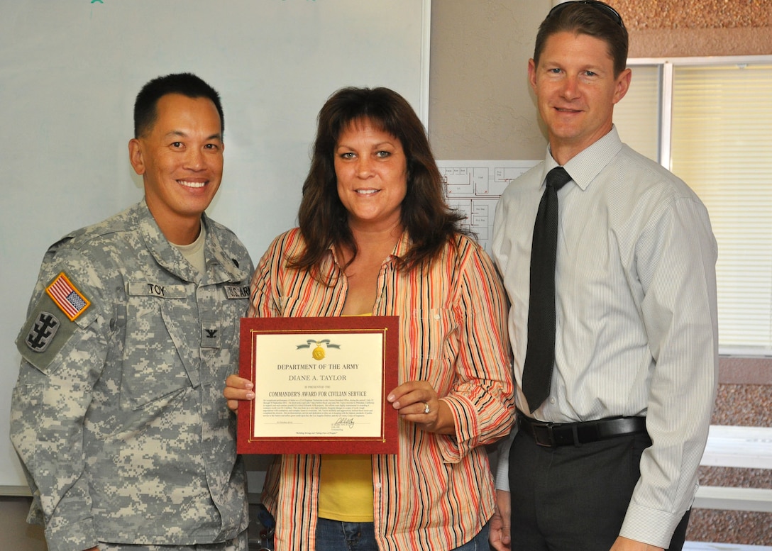 TUCSON, Ariz. - Diane Taylo, a civil engineering technician for the U.S. Army Corps of Engineers Los Angeles District Arizona-Nevada Area Office's Tucson Resident Office, receives a Commander's Award for Civilian Service from Col. Mark Toy, the LA District's commander, and David Van Dorpe, the LA District's Deputy District Engineer for Programs and Project Management during a Nov. 2 awards ceremony. Toy and Van Dorpe presented awards to District team members and spoke to them about the current direction of the District.