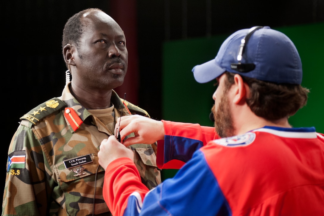 Col. Philip Aguer Panyang of the South Sudanese army gets help from Grant Stolz, studio manager at the Defense Media Activity, as he prepares to participate in a television interview during the media training portion of the Defense Information School’s Public Affairs Course for International Students curriculum at Fort Meade, Md., Nov. 2, 2012. DOD photo by Marvin Lynchard