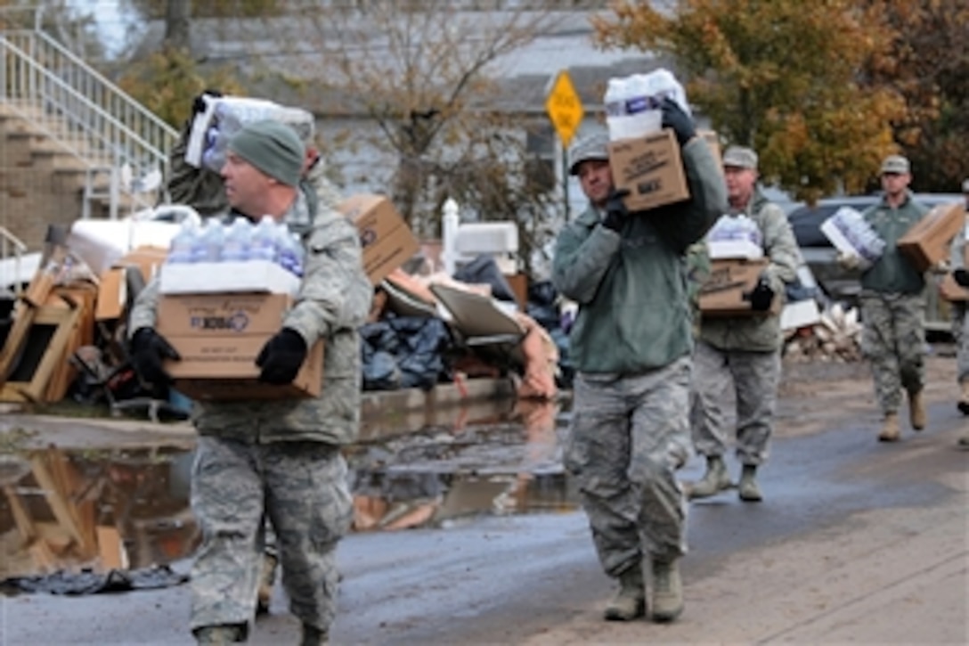 New York Air National Guardsmen and New York Army Guardsmen carry water and cases of food to residents in Staten Island, N.Y., on Nov. 1, 2012.  The food and water is being provided to people who needed assistance after hurricane Sandy took down power lines and caused massive destruction to many homes in the area.  