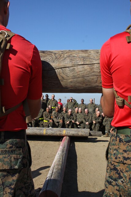 Drill instructors with Company D, 1st Recruit Training Battalion, demonstrate to recruits how to properly lift a approximately 250 pound log with teamwork aboard Marine Corps Recruit Depot San Diego, Oct. 30. Drill instructors emphasized to recruits that with out utilizing teamwork their exercises with the logs would be much more difficult. 