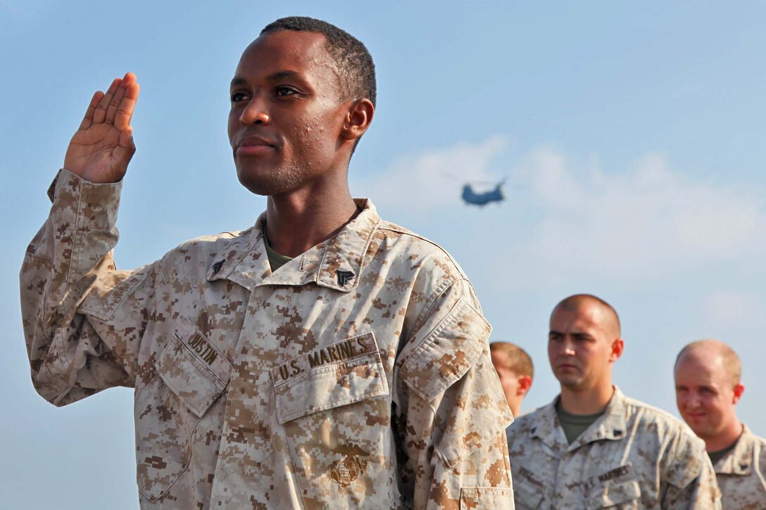 Corporal Pierre K. Justin, administration clerk, Command Element, 15th Marine Expeditionary Unit, re-enlists into the Marine Corps for another four years, aboard the USS Rushmore, Oct. 30. Justin was born in Port-au-Prince, Haiti, in 1990. At the age of 15, he left the Caribbean and moved to his father's house in New York City. He later joined the Marine Corps and earned his U.S. citizenship. The 15th MEU is deployed as part of the Peleliu Amphibious Ready Group as a theater reserve and crisis response force throughout U.S. Central Command and the U.S. 5th Fleet area of responsibility.