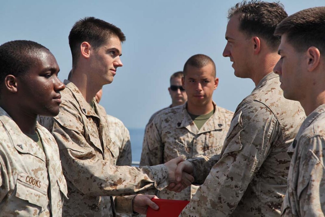 Corporal Timothy Childers, combat correspondent, Command Element, 15th Marine Expeditionary Unit, is promoted from lance corporal during a promotion ceremony on the flight deck of the USS Rushmore, Nov. 1. The 15th MEU is deployed with the Peleliu Amphibious Ready Group as a theater reserve and crisis response force throughout U.S. Central Command and the U.S. 5th Fleet area of responsibility