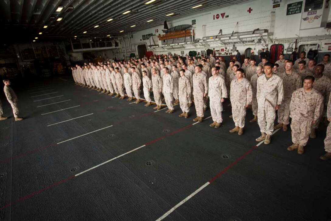 Marines and sailors of the Command Element, 15th Marine Expeditionary Unit,  stand in formation in the hanger bay of the USS Peleliu Nov. 1.  The first-of-the-month formation highlighted those Marines who received awards or were promoted.  The 15th MEU is deployed as part of the Peleliu Amphibious Ready Group as a theater reserve and crisis response force throughout U.S. Central Command and the U.S. 5th Fleet area of responsibility.