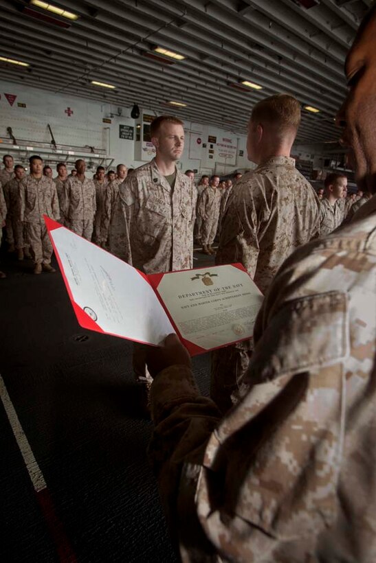 Staff Sgt. Loran Green, topographic chief, Command Element, 15th Marine Expeditionary Unit, receives a Navy and Marine Corps Achievement Medal for his performance during pre-deployment training in a ceremony in the hanger bay of the USS Peleliu Nov. 1.   The first-of-the-month formation highlighted those Marines who received awards or were promoted.  The 15th MEU is deployed as part of the Peleliu Amphibious Ready Group as a theater reserve and crisis response force throughout U.S. Central Command and the U.S. 5th Fleet area of responsibility