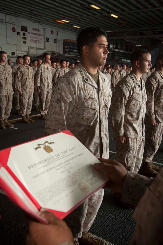 Sergeant Jacob Johnson, imagery analyst, Command Element, 15th Marine Expeditionary Unit, receives a Navy and Marine Corps Achievement Medal for his performance during pre-deployment training in a ceremony in the hanger bay of the USS Peleliu Nov. 1.   The first-of-the-month formation highlighted those Marines who received awards or were promoted.  The 15th MEU is deployed as part of the Peleliu Amphibious Ready Group as a theater reserve and crisis response force throughout U.S. Central Command and the U.S. 5th Fleet area of responsibility.