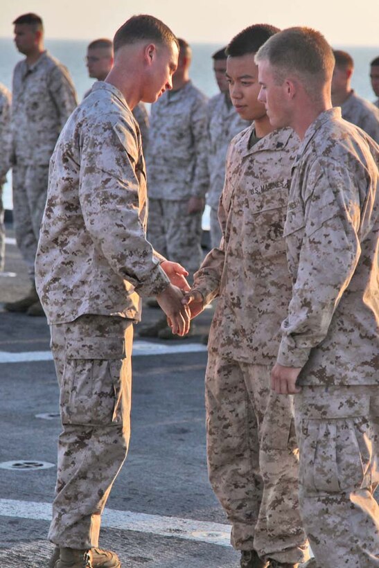 Corporal Bernard Vu, field radio operator, 2nd Platoon, Battery B, Battalion Landing Team 3/5, 15th Marine Expeditionary Unit, is promoted from lance corporal during a promotion ceremony on the flight deck of the USS Rushmore, Nov. 1. The 15th MEU is deployed with the Peleliu Amphibious Ready Group as a theater reserve and crisis response force throughout U.S. Central Command and the U.S. 5th Fleet area of responsibility. Vu, 20, is from Lincoln, Neb.