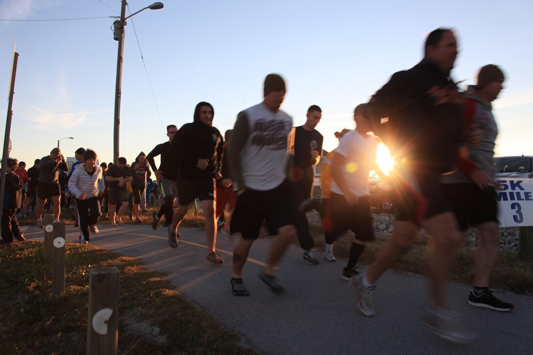 Marines and Sailors with U.S. Marine Corps Forces, Special Operations Command and their families start off on a 3-mile run at Topsail Beach, NC Nov. 3. The runners gathered Saturday morning to commemorate MARSOC's fallen heroes and to show support for their families. (U.S. Marine Corps photo by Cpl. Kyle McNally/Released)