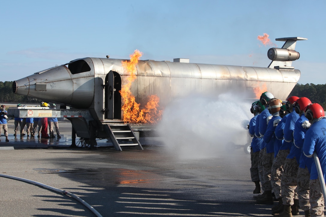 Marine Medium Tiltrotor Squadron 266 Re-enforced Marinesfight controlled training fires that engulf the mobile aircraft fire training device during shipboard firefighting training outside the Cherry Point Aircraft Rescue and Fire Fighting firehouse Nov. 2.  The MAFTD simulates an aircraft fire. 