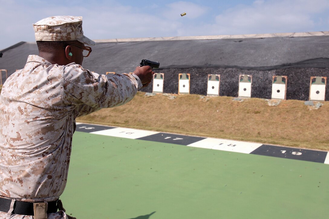Sgt. Marvilous M. McCammon fires the M9 service pistol on the pistol range at Camp Hansen during a combat marksmanship training course Oct. 29. Range coaches are entrusted to develop Marines by passing on the Corps’ time-honored tradition of precise marksmanship. McCammon is a student in the course and warehouse clerk with Combat Logistics Regiment 37, 3rd Marine Logistics Group, III Marine Expeditionary Force.  