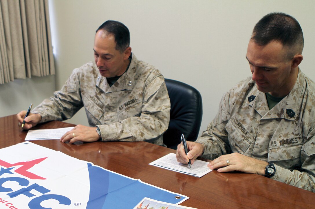 From left, Maj. Gen. Peter J. Talleri and Sgt. Maj. Patrick L. Kimble sign their Combined Federal Campaign-Overseas pledges at Camp Foster Oct. 31. Federal employees are able to donate to a variety of charitable organizations through the campaign. The program, which began 51 years ago, is the only authorized solicitation of federal employees on behalf of charitable organizations. The deadline to donate this year is Nov. 16. Talleri is the commanding general and Kimble is the sergeant major of Marine Corps Installations Pacific and Marine Corps Base Camp Butler. 