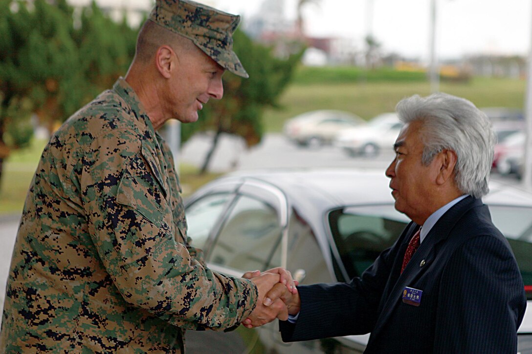 Col. John E. Kasperski welcomes Urasoe City Mayor Mitsuo Gima aboard Camp Kinser during a tour of the camp Nov. 5. Kasperski is the Camp Kinser camp commander and the commanding officer of Combat Logistics Regiment 37, 3rd Marine Logistics Group, III Marine Expeditionary Force. 
