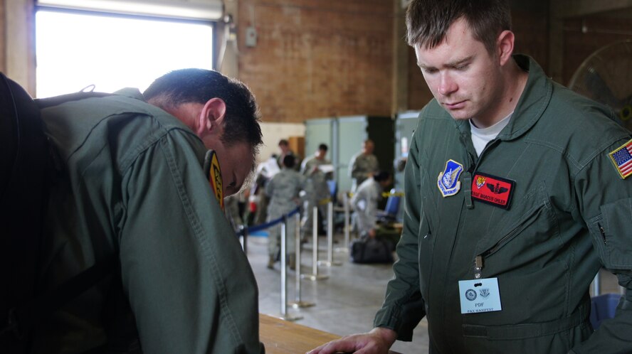 SSgt Marcus Ohler, 535 Airlift Squadron, assists Lt. Col. James Sage, 199th Fighter Squadron director of operations, process through a personnel deployment function line Nov. 7 during an exercise at Joint Base Pearl Harbor-Hickam, Hawaii. The PDF line tests the ability of Airmen to be medically, legally, administratively, spiritually, and financially ready to deploy, as well as the functionality of the processes in place with which to deploy them. (U.S. Air Force photo by Tech. Sgt. Andrew Jackson)