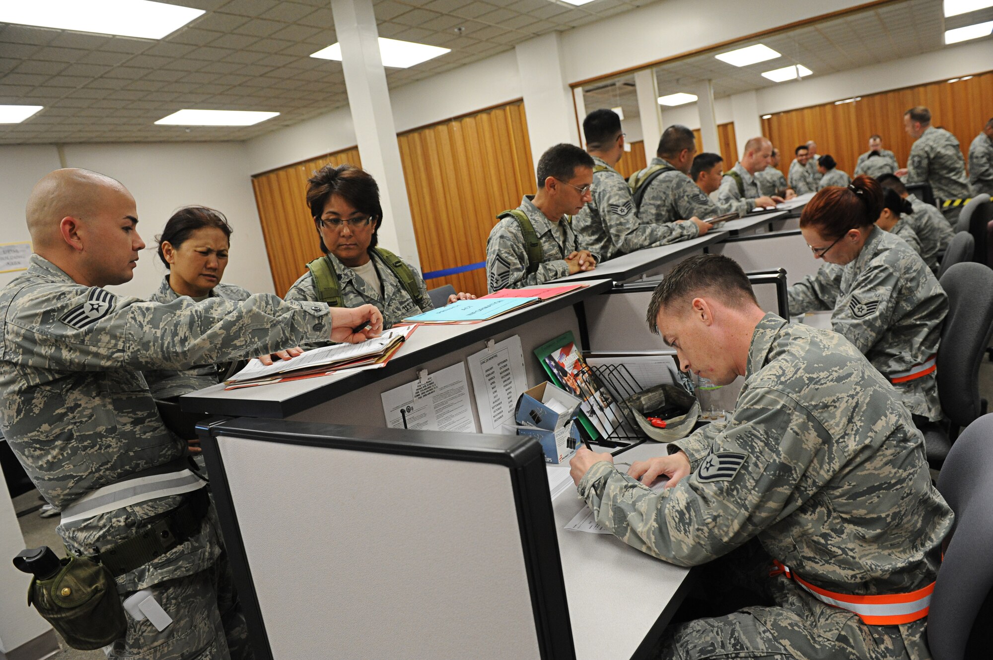 Airmen from the 154th and 15th Wings process through a personnel deployment function line Nov. 7 during an exercise at Joint Base Pearl Harbor-Hickam, Hawaii. The PDF line tests the ability of Airmen to be medically, legally, administratively, spiritually, and financially ready to deploy, as well as the functionality of the processes in place with which to deploy them. (U.S. Air Force photo/Senior Airman Lauren Main)
