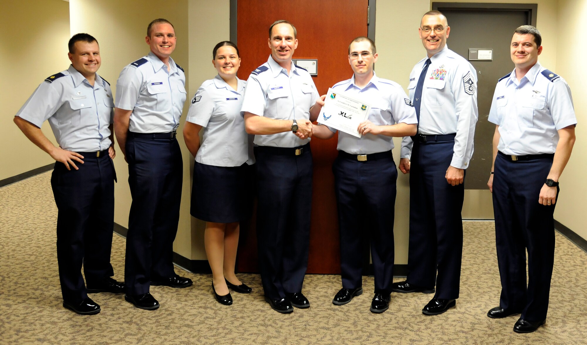 Senior Airman Andrew Carnahan, 47th FTW Command Post, poses with Col. Tom Murphy, 47th Flying Training Wing commander, and Chief Master Sgt. Garry Berry, 47th FTW command chief, after being presented the XLer of the week award at Laughlin Air Force Base, Texas, Oct. 29 , 2012. The XLer is a weekly award chosen by wing leadership and given to those who consistently make outstanding contributions to Laughlin and their unit. (U.S. Air Force photo/Airmen 1st Class Nathan Maysonet)